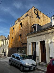 una macchina argentata parcheggiata di fronte a un edificio di 9WAGRAM Hotel Boutique a Le Mans