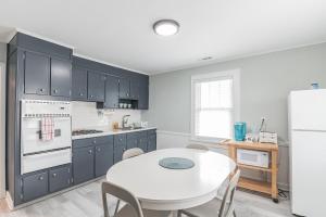 a kitchen with a white table and a white refrigerator at Large Patio with Ocean Views Beach Block Parking Unit 3 in Ventnor City