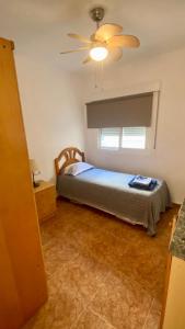 una camera con letto e ventilatore a soffitto di Apartamento en primera linea de mar. a Murcia
