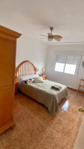 una camera con letto e ventilatore a soffitto di Apartamento en primera linea de mar. a Murcia