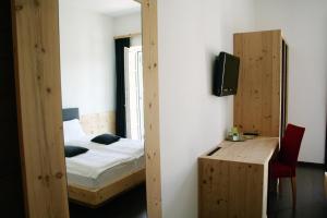 a bedroom with a bed and a desk and a television at Agriturismo Florandonole in Fai della Paganella