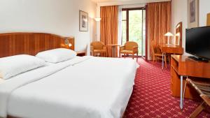 um quarto de hotel com uma cama e uma televisão de ecrã plano em OREA Spa Hotel Cristal em Mariánské Lázně