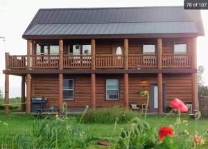 a log cabin with a deck and a house at Grand Teton Paradise Unmatched Views Hot Tub in Driggs