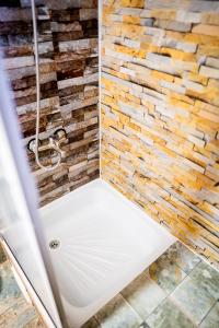 a bathroom with a stone wall and a brick wall at Hostal Alcázar in Puerto Natales