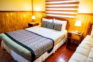 a bedroom with a large bed with two night stands at Hostal Alcázar in Puerto Natales