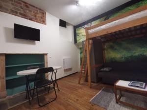 Cette chambre comprend une mezzanine, une table et des chaises. dans l'établissement La Maison bleue, un emplacement de choix à Rodez, à Rodez