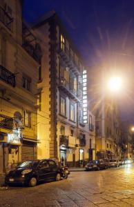a street with cars parked next to buildings at night at Albergo del Golfo in Naples