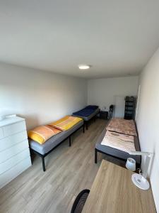 Zimmer mit 3 Betten und einem Schreibtisch. in der Unterkunft Nice, big and central apartment with 2 balconies in Karlsruhe