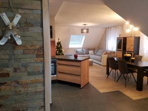 eine Küche und ein Wohnzimmer mit einem Sofa und einem Tisch in der Unterkunft Gîte Les terrasses du Mambourg à Kaysersberg-Vignoble in Kaysersberg