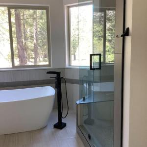 ein Bad mit einer Badewanne und einem Fenster in der Unterkunft King Bed New Build Christmas Valley Garage Parking in South Lake Tahoe