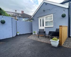 a blue house with two chairs and a fence at Westend Holiday Let 2 Brecon in Brecon