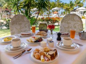 a table with breakfast foods and drinks on it at Hotel Marina Porto Abrolhos in Caravellas
