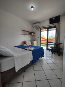 1 dormitorio con cama y vistas a un patio en Pousada Boto Mar, en Garopaba