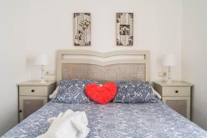 un letto con un cuscino rosso a forma di cuore di Benalbeach Sea Front a Benalmádena