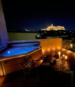 a hot tub on top of a building at night at Cittadella View Penthouse with Jacuzzi in Victoria