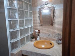 a bathroom with a brown sink and a mirror at Jaye’s Home in Arona