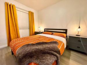 a bedroom with a bed with an orange comforter at Quiet Remodeled 3 Bedroom in Heart of Downtown Sacramento in Sacramento