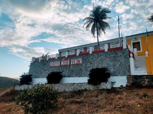 a building with a palm tree on top of it at Pousada Maria Bonita - Piranhas, Alagoas. in Piranhas