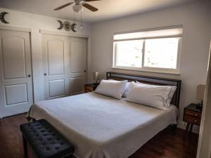 a bedroom with a bed with white sheets and a window at Pool! Quite, Private, remodeled home on the hill in Placerville +26 photos