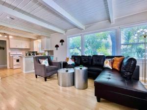 a living room with a black leather couch and chairs at Uniquely styled home minutes to Downtown Sac! in West Sacramento