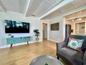 a living room with a couch and a flat screen tv at Uniquely styled home minutes to Downtown Sac! in West Sacramento