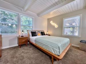 a bedroom with a bed and two windows at Uniquely styled home minutes to Downtown Sac! in West Sacramento