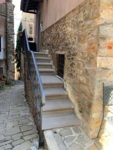 una rampa di scale accanto a un edificio in pietra di La Casa dei Nonni a Castagneto Carducci