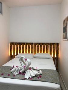 2 cisnes toalhas numa cama num quarto em THEMATIC POUSADA em João Pessoa