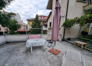 a patio with a bed and an umbrella next to a building at Tsar Simeon, 2 bedroom, living room and fireplace in Sofia
