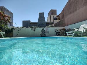 une grande piscine d'eau avec une statue en arrière-plan dans l'établissement Pousada Boto Mar, à Garopaba