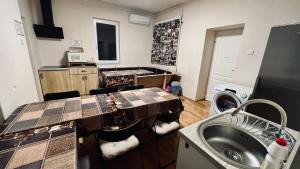 a bathroom with a sink and a washing machine at Csatangoló Lovas Vendégház 