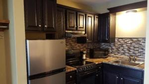 a kitchen with wooden cabinets and a stainless steel refrigerator at Jackson Town House Inn in Jackson