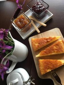 une table avec deux assiettes de nourriture et une table de confiture dans l'établissement Casa das Quintas, à Quinta das Quebradas