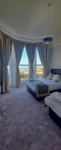 sypialnia z 2 łóżkami i dużym oknem w obiekcie Alexandra Hotel w mieście Eastbourne