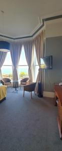 a living room with a large window and a television at Alexandra Hotel in Eastbourne