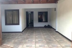 um quarto vazio com paredes brancas e piso em azulejo em Alojamiento entero 1 km Juan Santamaría Airport em Alajuela