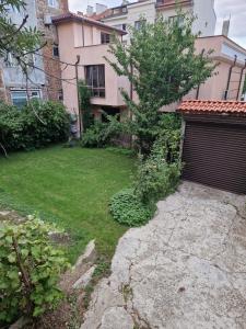 a yard in front of a house with a garage at Tsar Simeon, 2 bedroom, living room and fireplace in Sofia