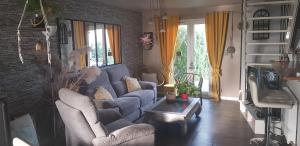 ein Wohnzimmer mit einem blauen Sofa und einem TV in der Unterkunft Chez Marie Laure in Nogent-le-Rotrou