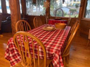 Union Bay Log Home في Union Bay: طاولة غرفة الطعام مع طاولة قماش حمراء وبيضاء