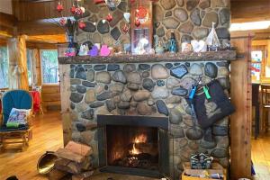 a fireplace in a living room with a stone wall at Union Bay Log Home in Union Bay