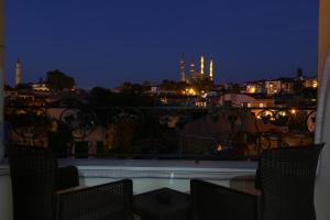 a balcony with chairs and a view of a city at night at MAÇA OTEL in Edirne
