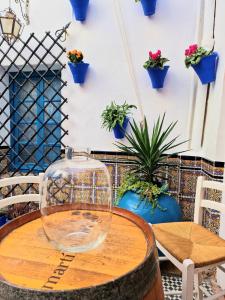 Arc House Mezquita - Only adults في قرطبة: وعاء زجاجي على طاولة خشبية مع نباتات الفخار