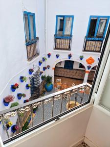 Arc House Mezquita - Only adults في قرطبة: شرفة في مبنى به نوافذ زرقاء ونباتات