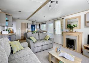 uma sala de estar com dois sofás e uma lareira em Willows Holiday Park em Withernsea