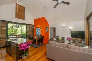 een woonkamer met een bank en een tafel bij Cook Islands Holiday Villas - Turtle Villa in Arorangi
