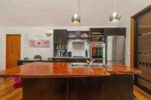 a kitchen with a wooden counter top and a sink at Cook Islands Holiday Villas - Turtle Villa in Arorangi