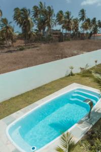 a swimming pool on the side of a house at Pousada Naná in Prea