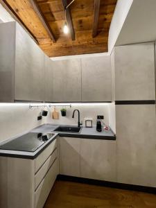 a kitchen with white cabinets and a wooden ceiling at La dimora della Giudecca - 13 in Cuneo
