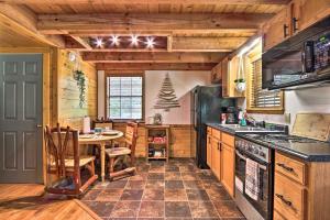 a kitchen with a table and a stove top oven at CREEKSIDE Tiny Cabin by Pigeon Forge in Sevierville +27 photos