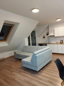 ein Wohnzimmer mit einem blauen Sofa und einer Küche in der Unterkunft Apartament Marzenie 4 - Opole in Oppeln